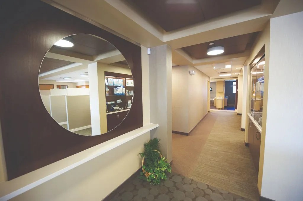 Office tour of the hallway with a circle mirror on wall 