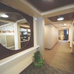 Office tour of the hallway with a circle mirror on wall 