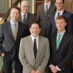 Picture of all Dr's in the practice dressed in suits on the interior stairs 