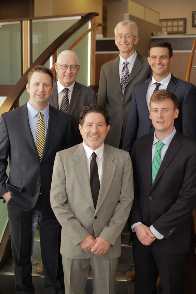 Picture of all Dr's in the practice dressed in suits on the interior stairs 