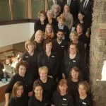 Picture of the staff and the Dr's all standing on the interior stairs 