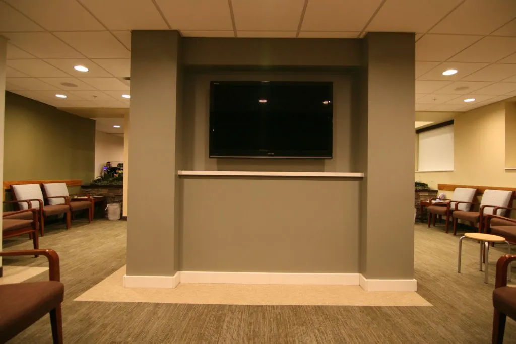 Waiting room with TV screen and chairs 